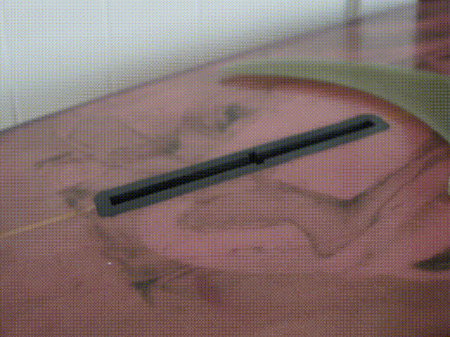 stop motion gif of the ez-nut installing itself into a pink surfboard. white background. Semi-transparent single fin.
