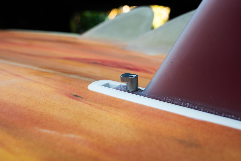 Close-up of surfboard with a metal screw, blurred background